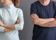 A man and a woman standing next to each other with their arms crossed. They are either seperated or divorced.