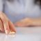 A woman placing her wedding ring on a marble table.