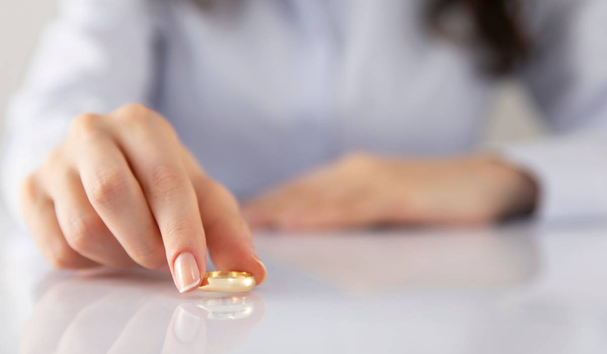 A woman placing her wedding ring on a marble table.